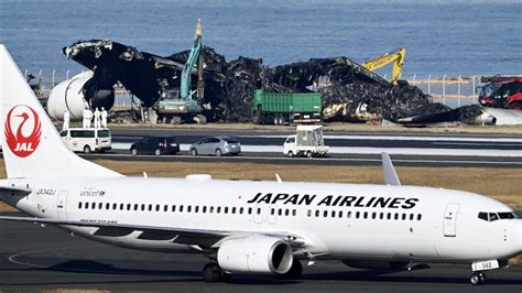 Japanese safety experts search for voice data as workers clear plane debris from runway collision